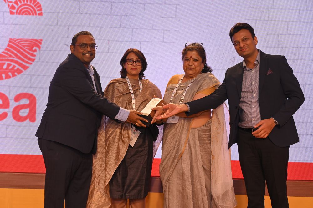 Anuradha Chatterjee and Aditti Gogiyaa receiving the Times of India’s Leadership in Advancing Gender Equality award for CREA from two presenters on stage.

