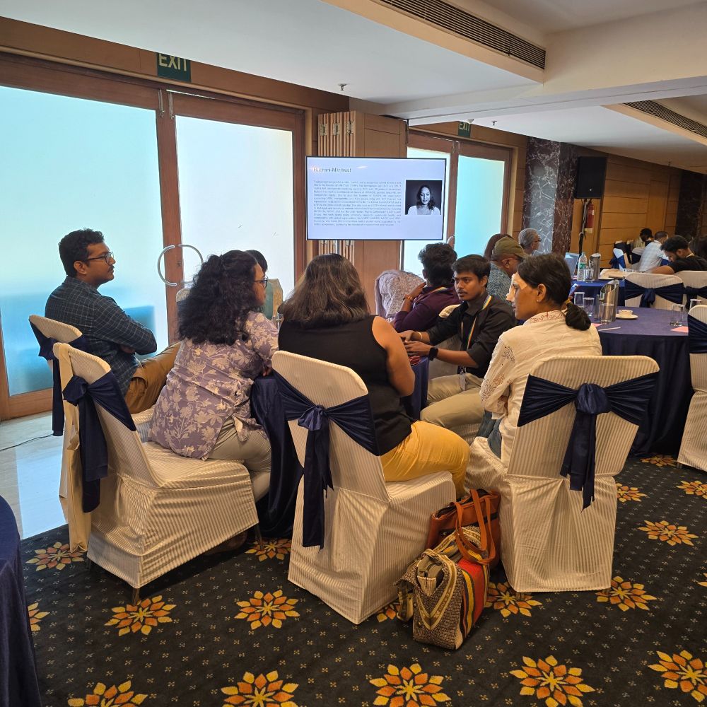 
Image of people sitting in a semicircle involved in a group-discussion. There a white screen behind them.