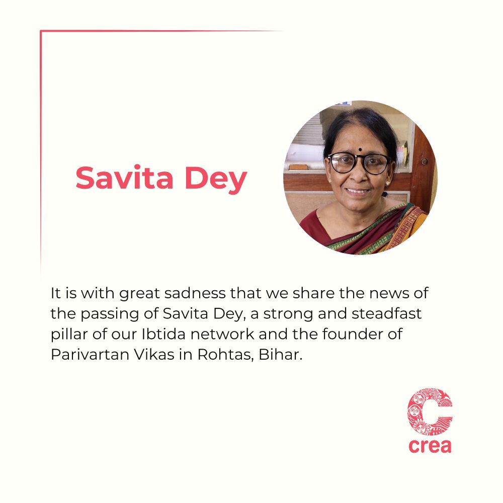 The image features off-white background with a red border line at the top left.

On the left side, bold red text reads "Savita Dey".

On the right, there is a circular photograph of Savita Dey smiling, wearing a green and yellow saree with a maroon blouse and black bindi, seated against a wooden background.

Below, in black text, it reads:
"It is with great sadness that we share the news of the passing of Savita Dey, a strong and steadfast pillar of our Ibtida network and the founder of Parivartan Vikas in Rohtas, Bihar."

The CREA logo, in red, appears at the bottom right corner.