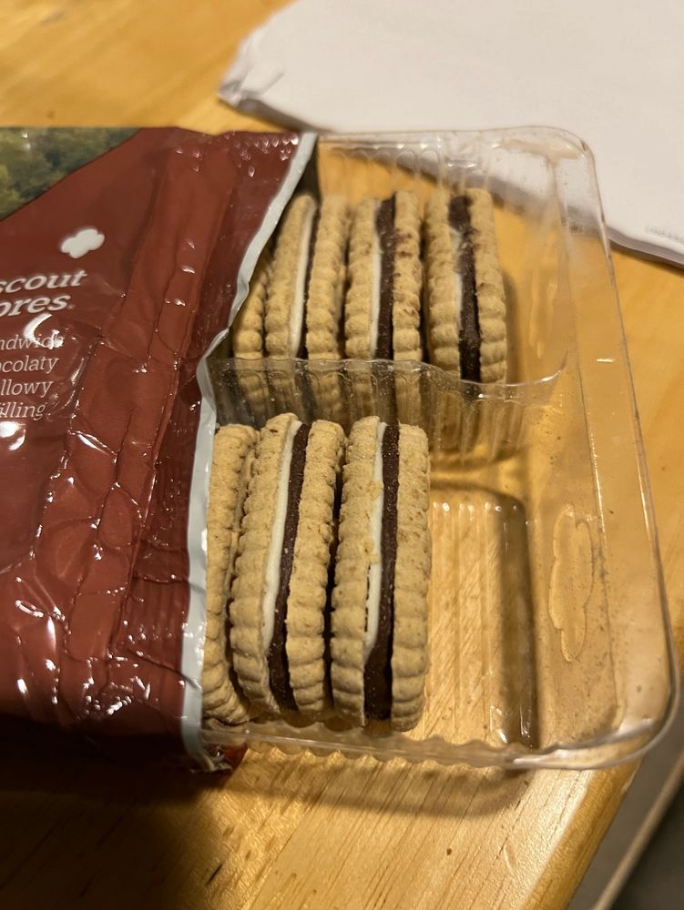 A freshly opened package of girl scout cookies with on missing cookie
