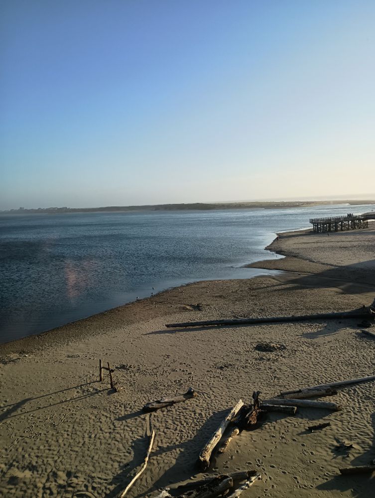 Siletz Bay view from the 4th floor, as the tide is going out so more sandy shore and shallow water, near sunset  with clear blue skies 