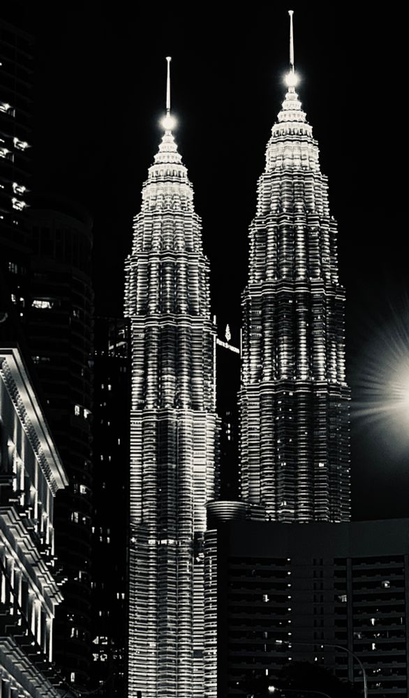A monochrome image of the Petronas Towers in Kuala Lumpur captured at night.