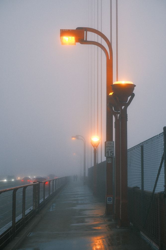Fog obscures the distance crossing the Golden Gate Bridge.