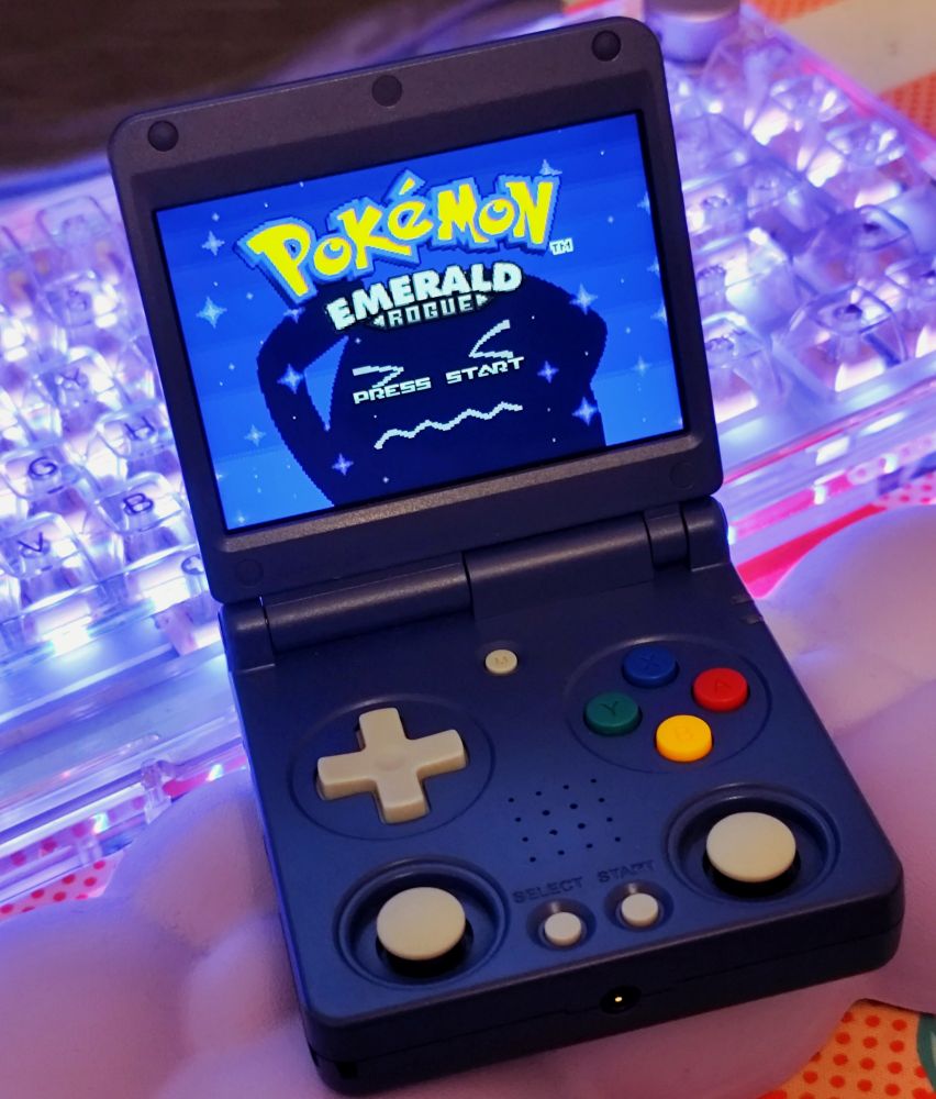gameboy sp like handheld infront of an acrylic keyboard