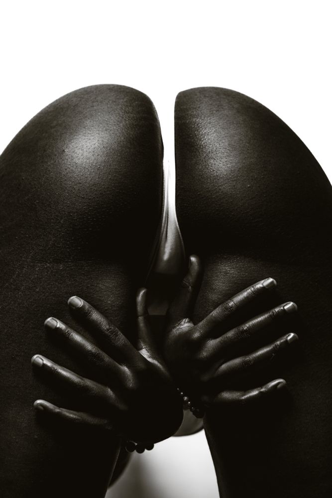 A high saturation picture of Aslan from behind, bent over with her hands coming out from under her
