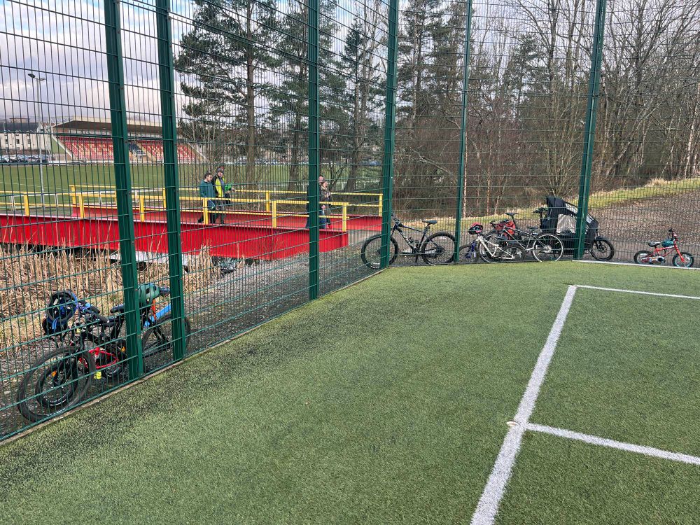 Bikes around a playing field fence 