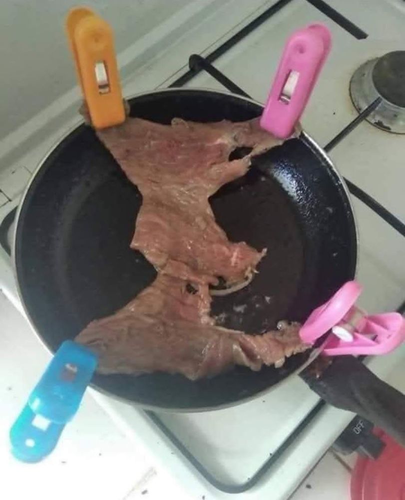 Um Bife esticado numa frigideira por meio de grampos presos em quatro cantos, puxando o bife.