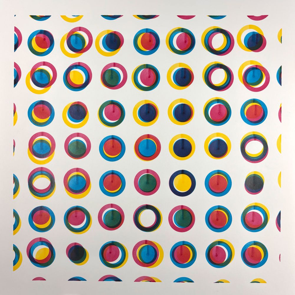 A square grid of evenly spaced circles, each filled with overlapping arcs of cyan, magenta, yellow, and black. Though every circle follows the same basic structure, the orientation and layering vary, creating a wide range of color blends and visual rhythms. The piece has a clean white background and a precise grid layout, but the overlapping transparencies and rotational variance add energy and complexity to each individual unit.