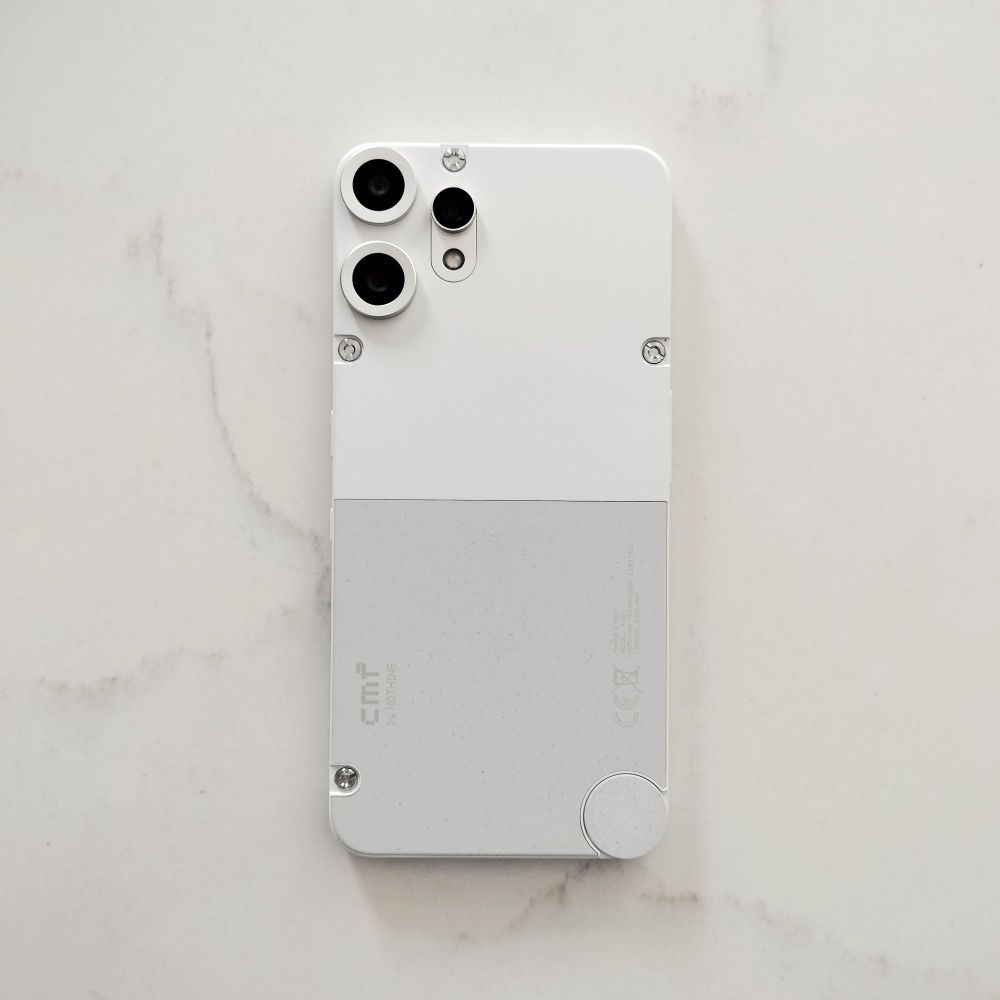 a photo of the back of the CMF Phone 2 Pro showing the two toned white/urey back and the three camera lenses. Several exposed screws give it a technical look which I quite like. 
