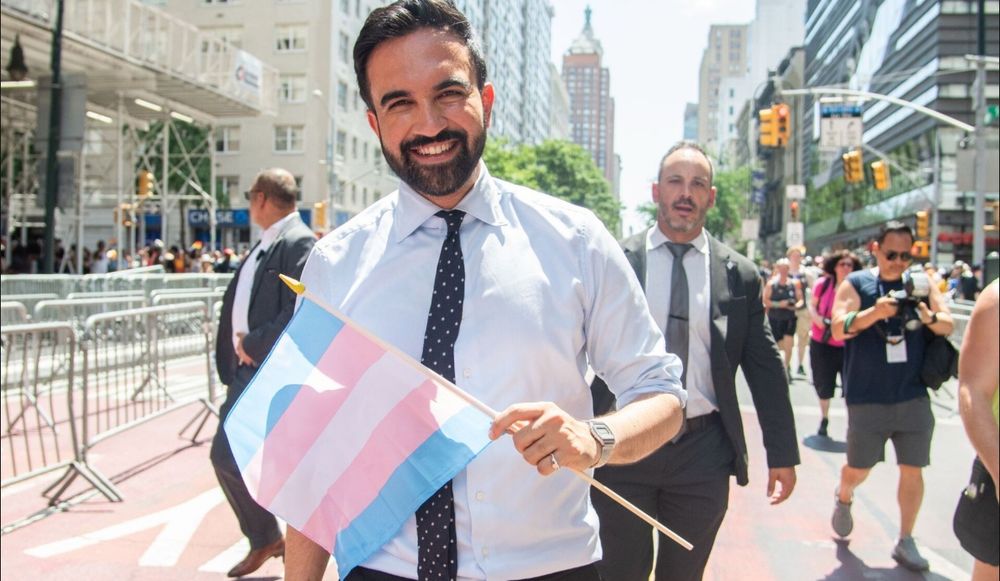Zohran Mamdani holding Trans Flag cause hes a fucking awesome person