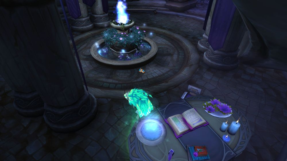 A study nook for magical elves in World of Wacraft. There's a glowing magic bowl resting on a desk with some candles, while the player is pointing out a tranquil fountain in the center of the room with glowing flowers, plants and magic flowing at the top of it.