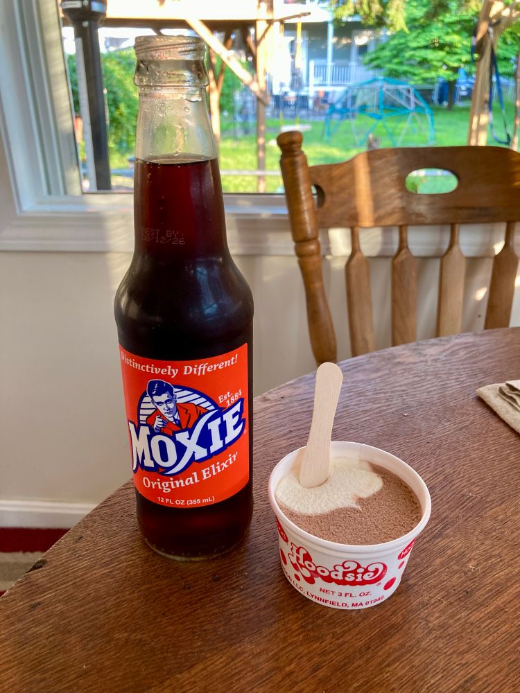 photo of a bottle of Moxie soda and a Hoodsie Cup ice cream 