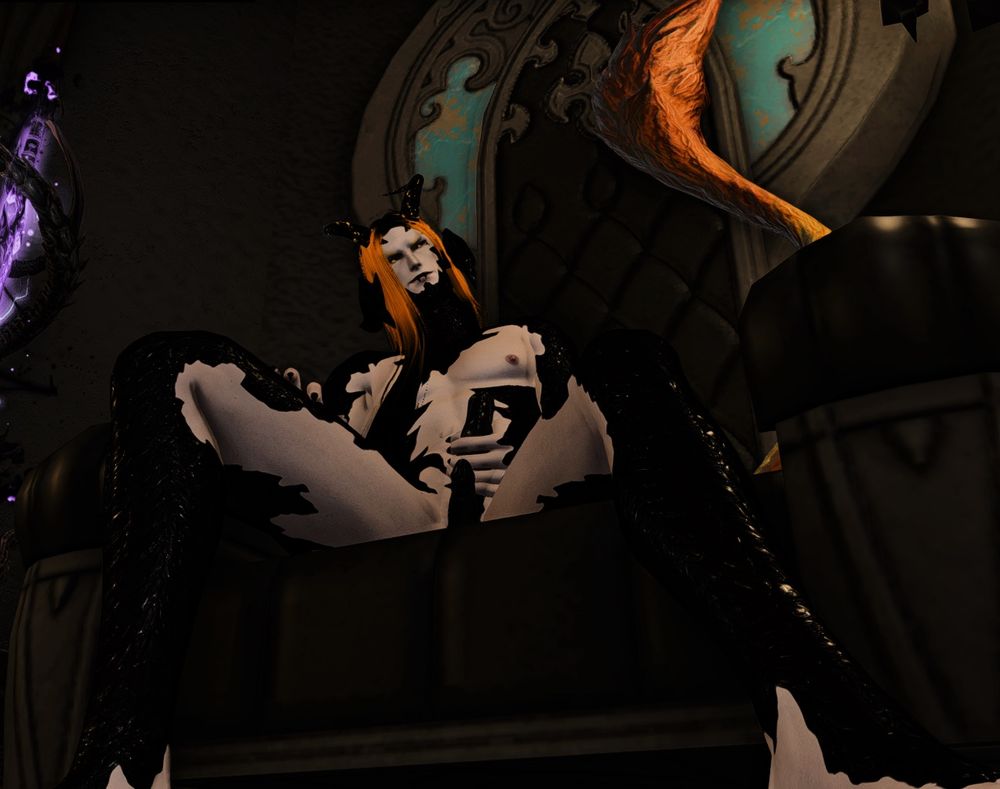 Black and yellow Au Ra sitting naked, legs spread wide, while he holds the bigger of his two penises with a smirk on his face.