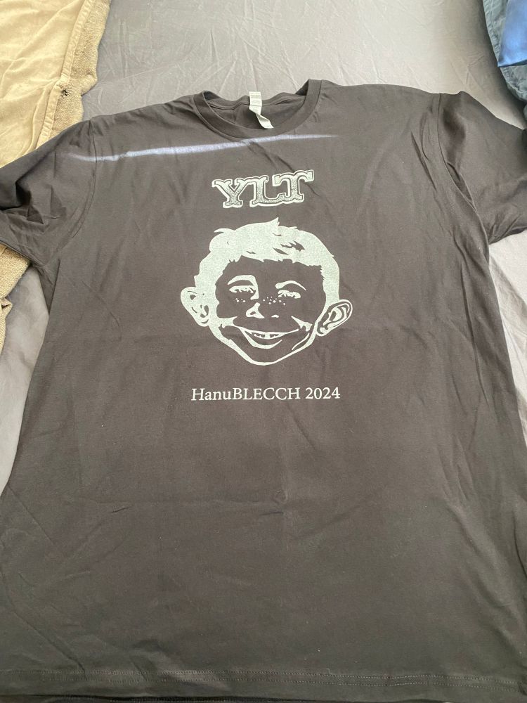 Black concert t-shirt from Yo la Tengo’s 2024 Hanukkah shows with a white negative image of Mad Magazine’s Alfred E Newman