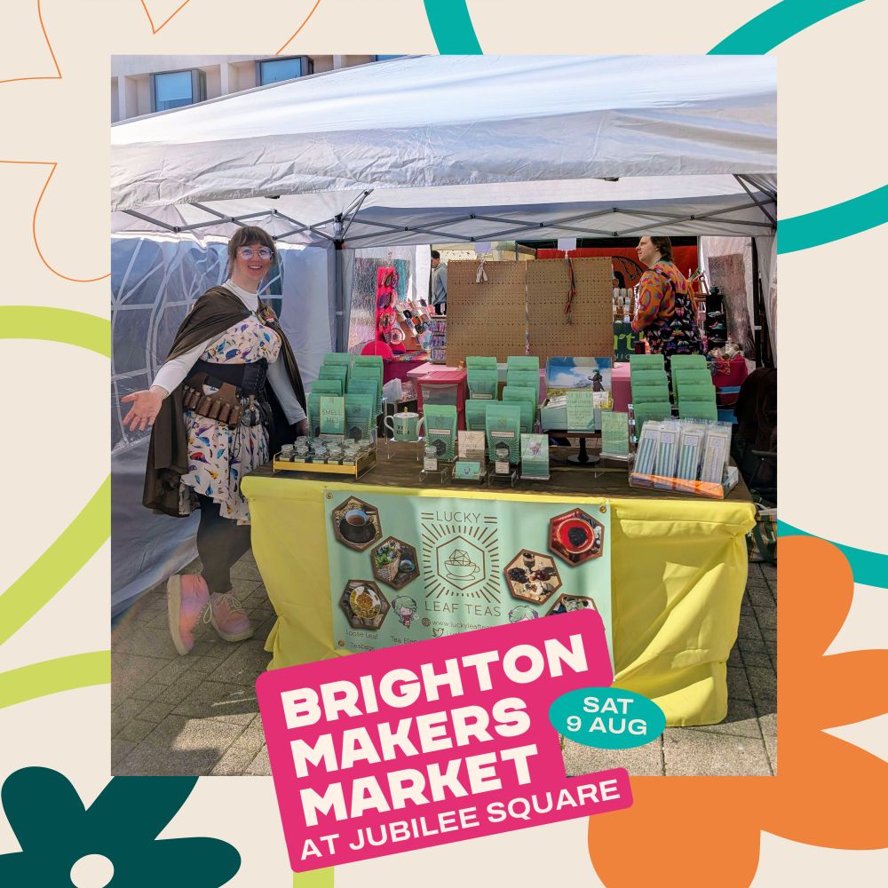 The Lucky Leaf Teas market stall, covered in mint-green pouches of tea, underneath a gazebo. A banner declaring the name of the brand hangs from the front. Arianne stands to the side, arm out, smiling. A border surrounds the picture, with the message "Brighton Maker's Market at Jubilee Square - Saturday 9th August."