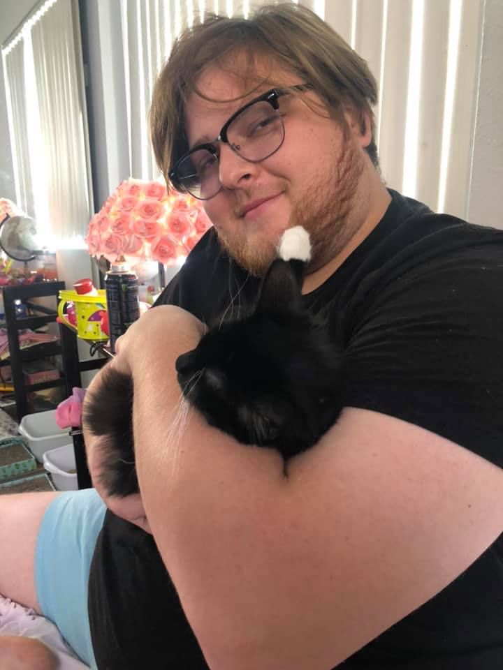 Stephen holding our little tuxedo cat, Hades. 