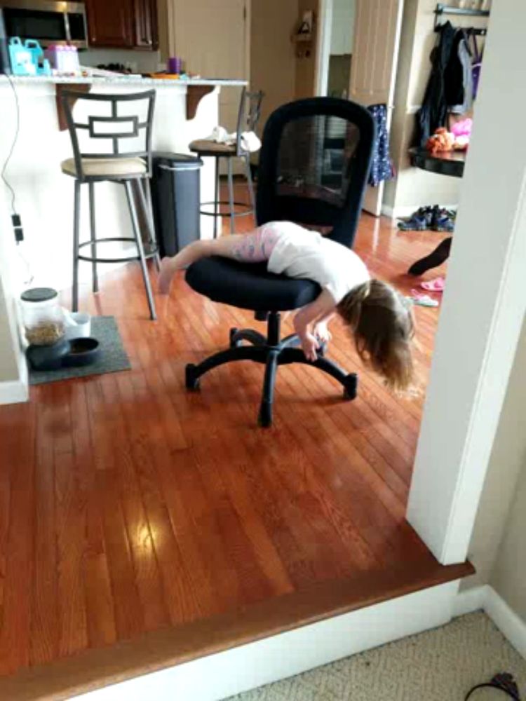 a little girl sits on a chair in a room