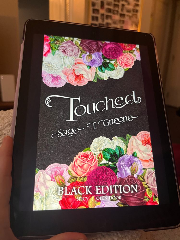 Image of an iPad with the cover a book called Touched by Sage T. Greene with floral imagery 