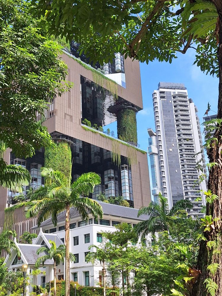 High rise building in singapore with extensive plants along columns. 