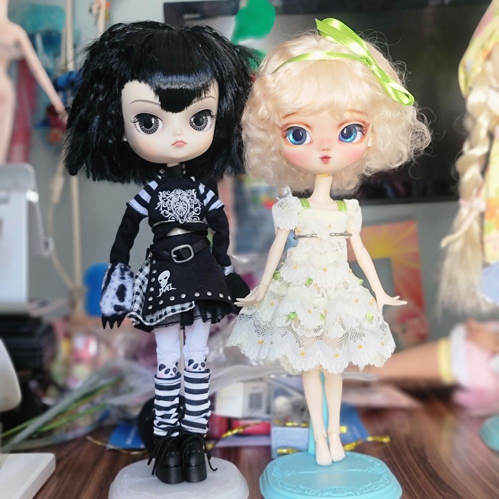 Dal Tezca - a gothy Dal doll, next to Yeolume Guelder Rose, a blonde doll dressed in a frilly lace dress. 