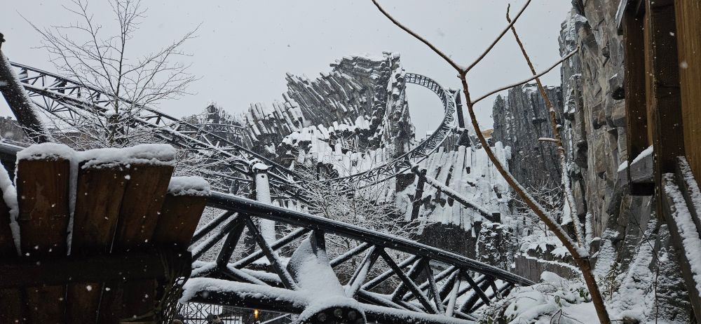 La zone de la montagne russe Taron à Phantasialand sous un épais manteaux de neige, la zone est traversée de très nombreuses fois par des rails se faufilant entre les structures basaltiques.