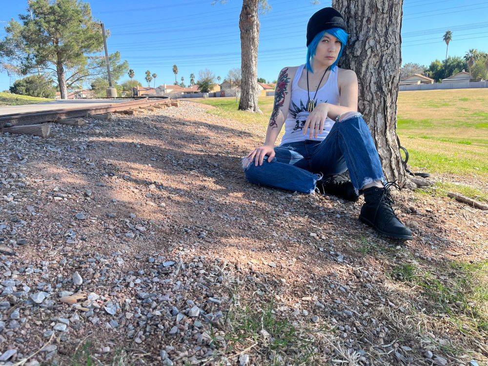 Me cosplaying Chloe Price from Life is Strange. I'm sitting by a tree