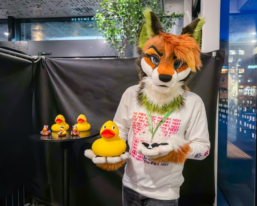 A fox presenting a rubber duck in their paw. 