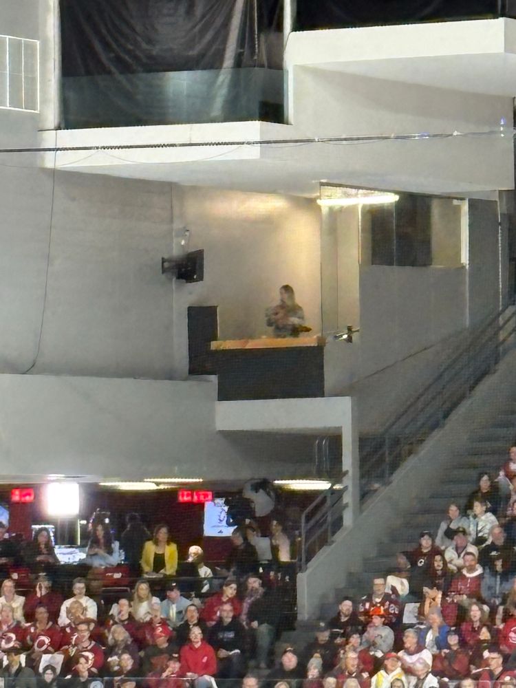 a very blurry far away blonde woman rocking a baby