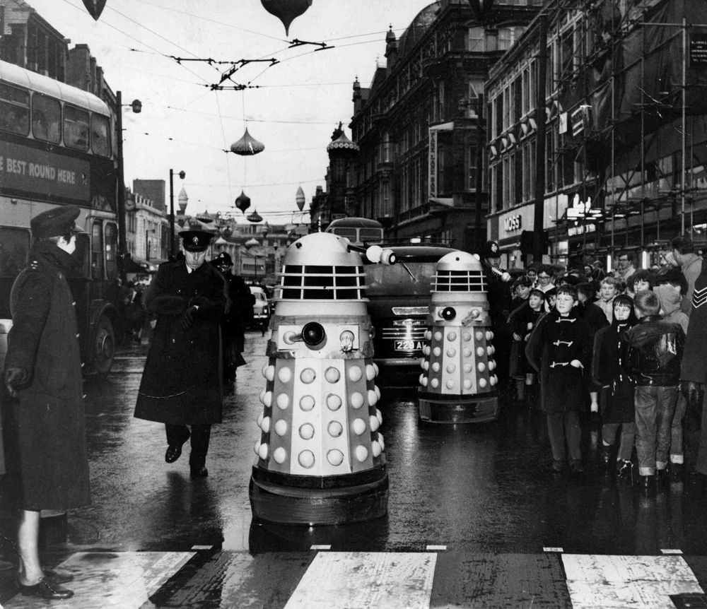 Police Inspector Glyn Pockett escorts two Daleks on their journey along St Mary Street, Cardiff. 12th December, 1964.