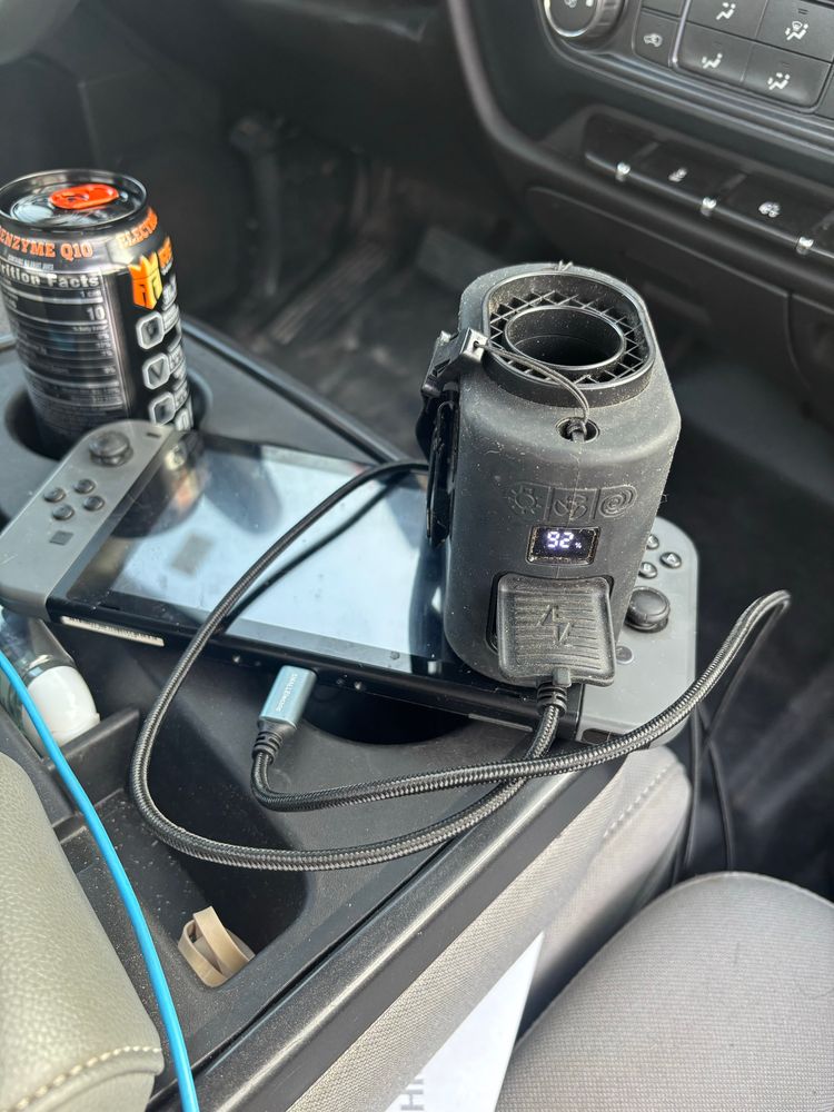 A picture of a Nintendo switch being charged by a portable fan.
