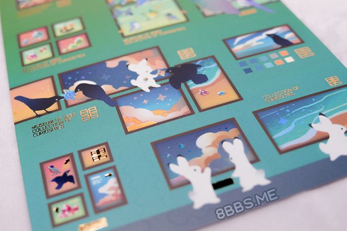 Close-up photo of the lower half of a foiled sticker sheet featuring rabbits and crows in a museum/gallery sort of setting. Light catches on the clear holo foil making it look faintly rainbow.