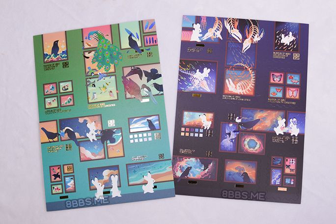 Photo of 2 foiled sticker sheets featuring rabbits and crows in a museum/gallery sort of setting.