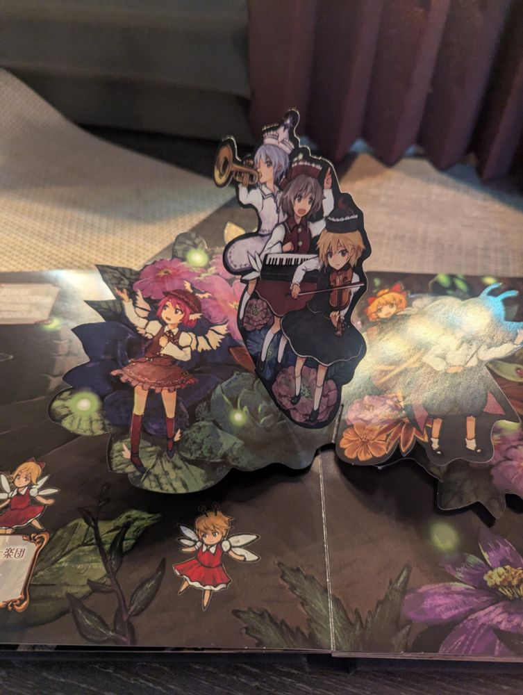 A pop up illustration shows a group of girls performing a song while surrounded by fairies.