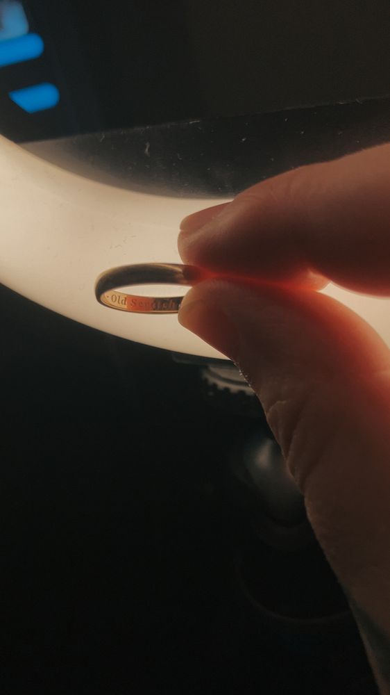 A photo of a wedding ring. Inside it says «Old Scratch» 
