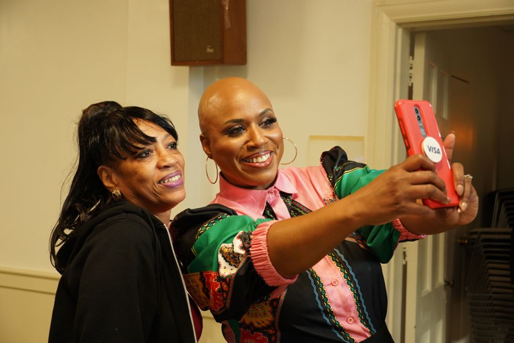 Rep. Ayanna Pressley takes a selfie with an attendee.