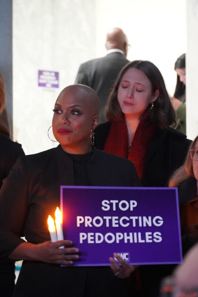 Rep. Ayanna Pressley holds a sign that reads: Stop Protecting Pedophiles.
