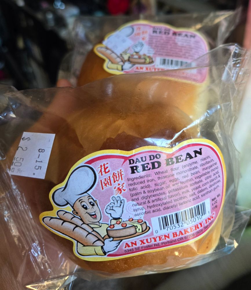 Shrink wrapped red bean buns from An Xuyen bakery with a picture of a smiling chef holding baguettes and cake 