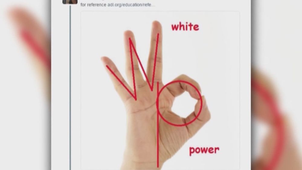 A reference image from the ADL website. Picture is a White person's right hand raised in the okay hand sign against a white background. A red W is superimposed over the three raised fingers. A red P is superimposed over the circle formed by the index finger and thumb with the line of the P running down the wrist. The word white is written by the W and the word power is written by the P.