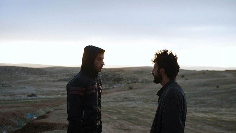 Plan du film. Badel Adra et Yuval Abraham qui se regardent face aux terres de Masafer Yatta
