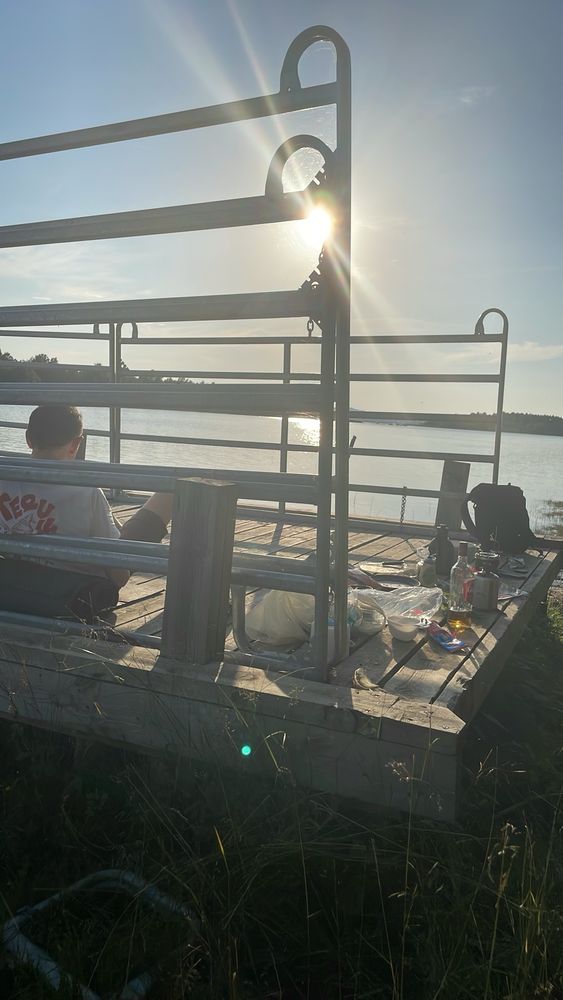 Brygga i kvällsmotljus med middag uppdukad på landsidan.