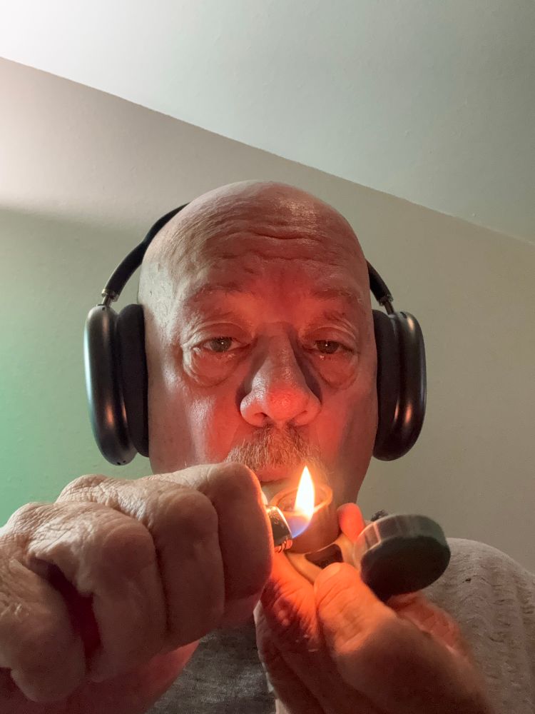 Scott in his AirPods lights his marijuana pipe attempting to get “stoned to death” 