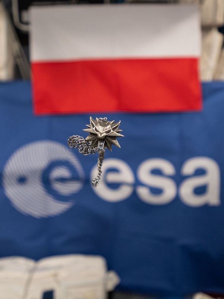 Geralt's wolf medallion floating in space, with ESA logo as backdrop