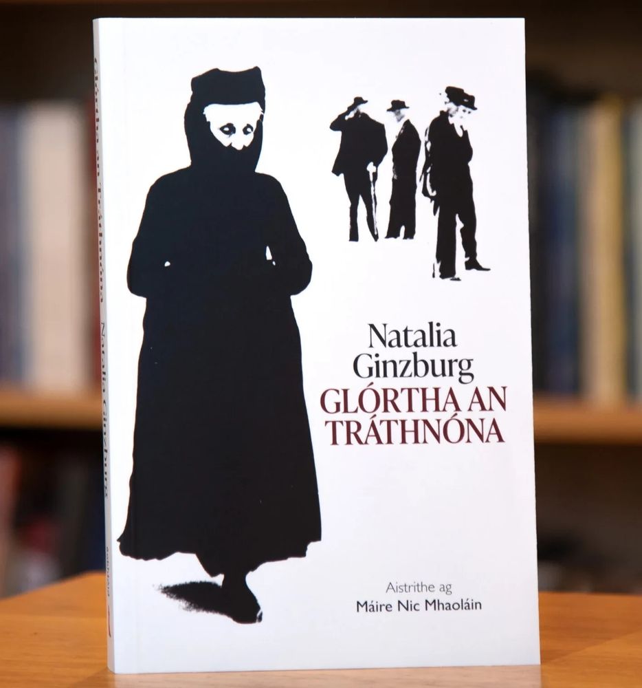 Clúdach an leabhair Glórtha an Tráthnóna le Natalia Ginzburg le grianghraif a thóg Mario Giacomelli de bhean gléasta in éadaí thraidisiúnta dhubh agus ceathrar fear i gcultacha sa chlúlra ag amharc uirthi 