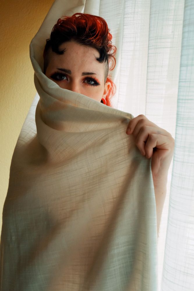 Bex wrapped in the window curtain in a hotel room