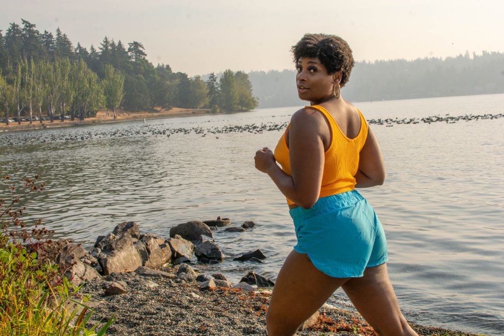 Kelly jogging along the lake at golden hour 