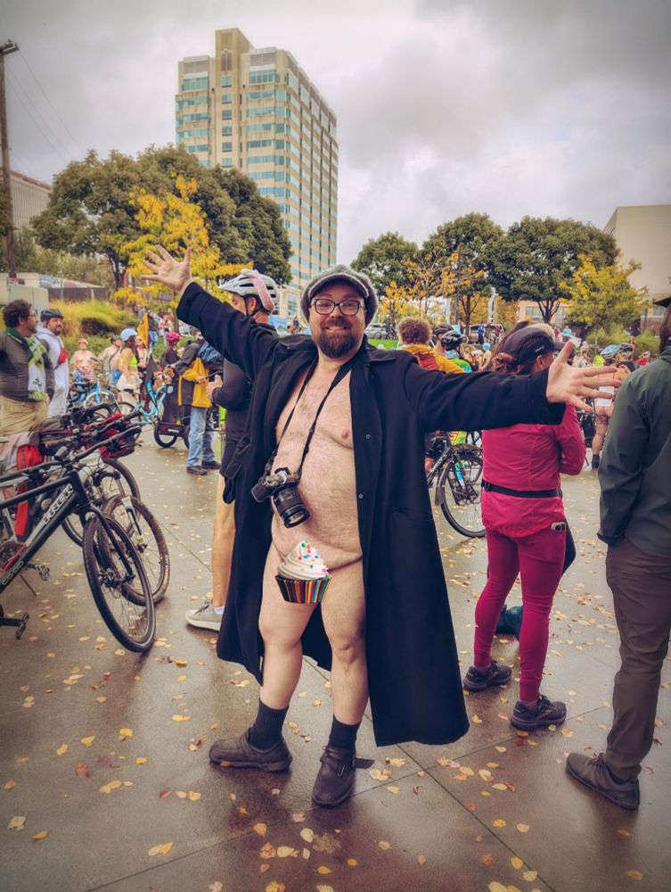 Nathaniel in a long black coat at the Portland emergency naked bike ride 