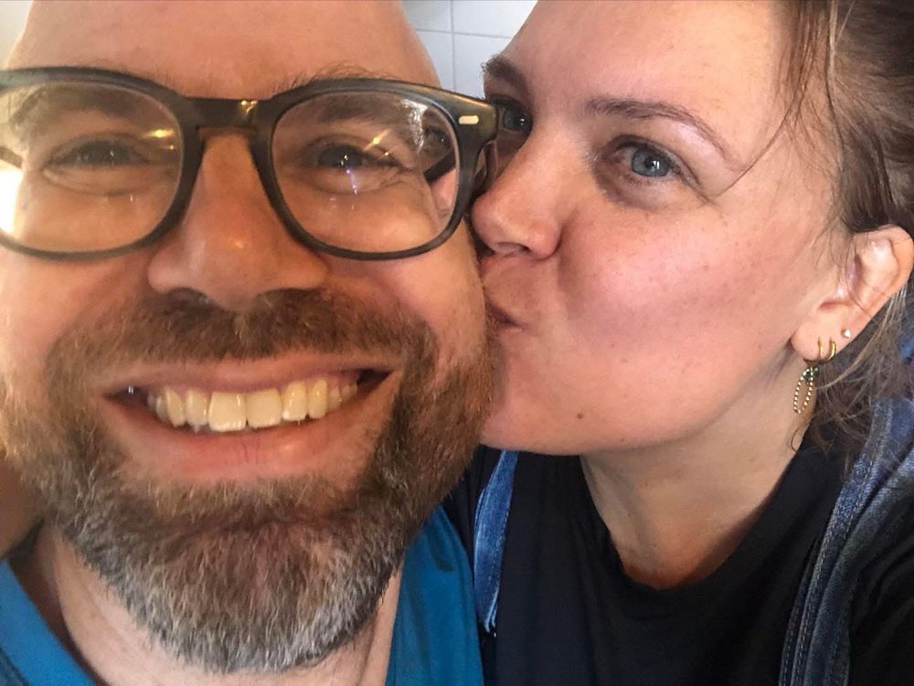 Two persons, one kissing the other