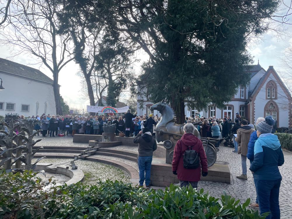 Foto einer Gruppe von Menschen in Herxheim, die für Demokratie, Menschenrechte und Frieden singen.