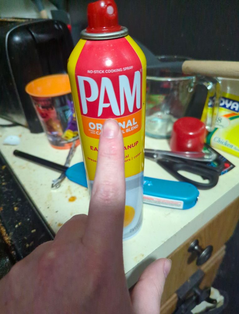 A picture of me pointing at a can of PAM cooking spray.