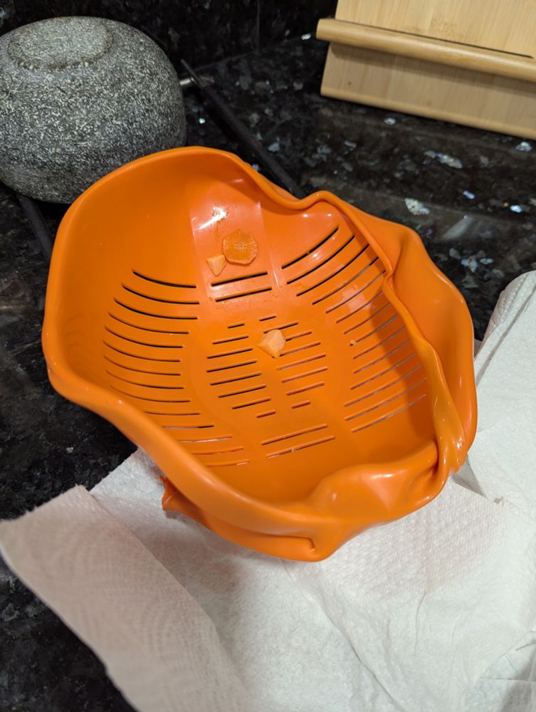 A very warped colander due to a stint in the oven 